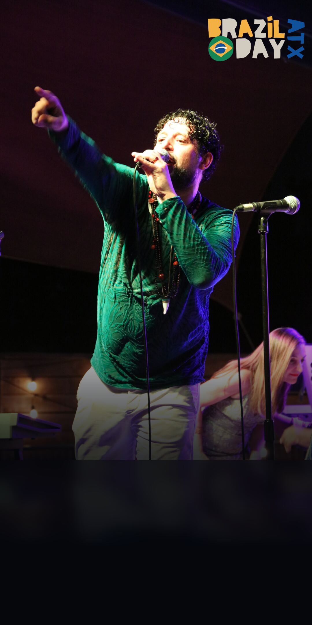 Frederico7 & Banda — Frederico7 singing into the microphone with his arm raised on stage