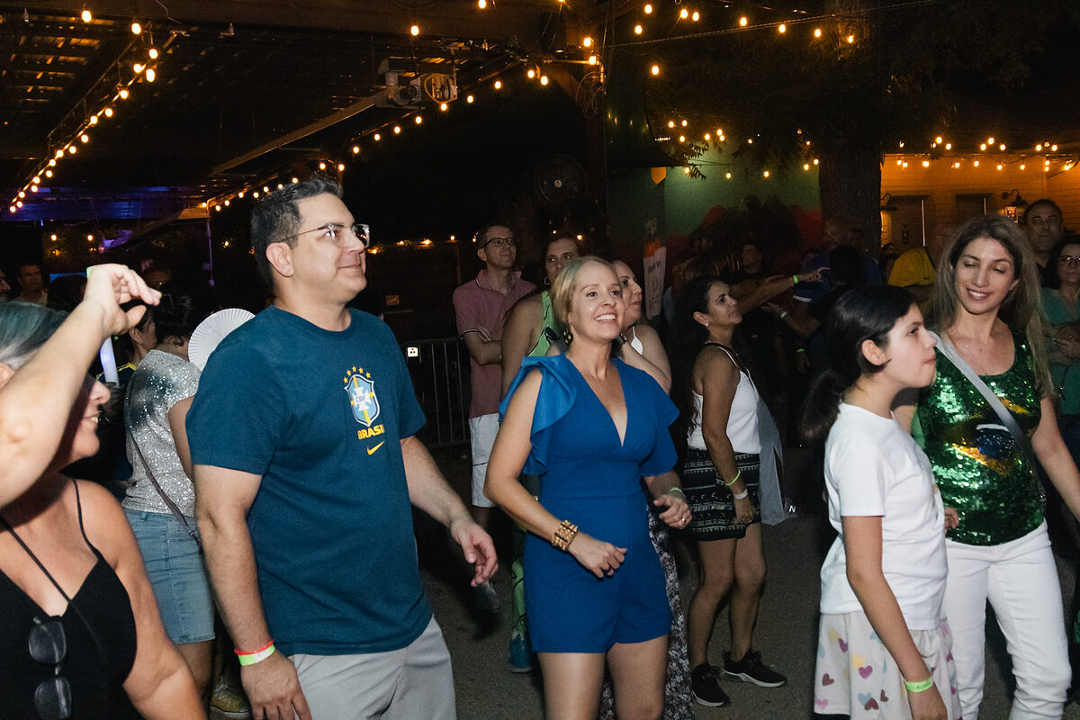 Famílias e amigos da comunidade brasileira reunidos durante celebração cultural em Austin, Texas