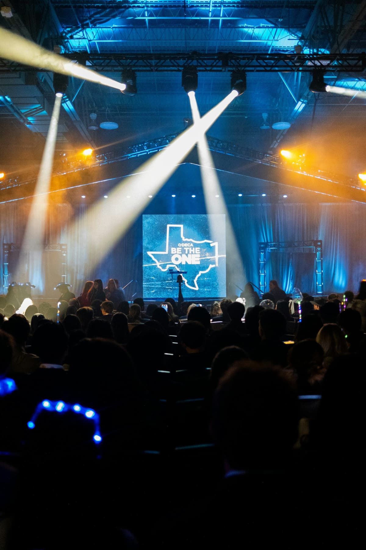 Spotlights over a conference stage and its audience