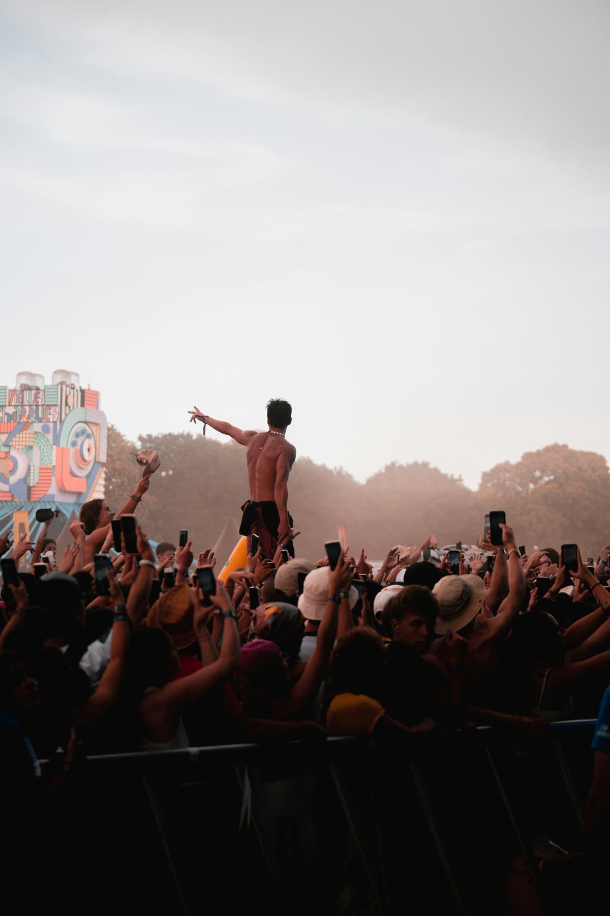 A festival crowd with one fan lifted above it