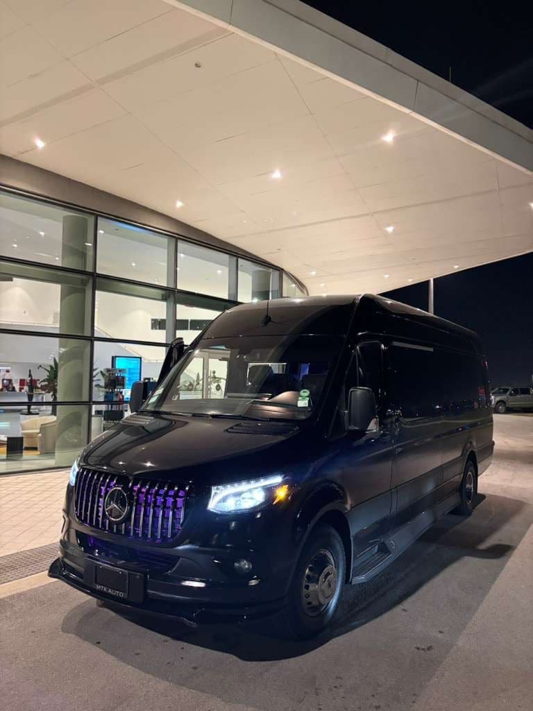 A black Sprinter waiting outside a venue at night