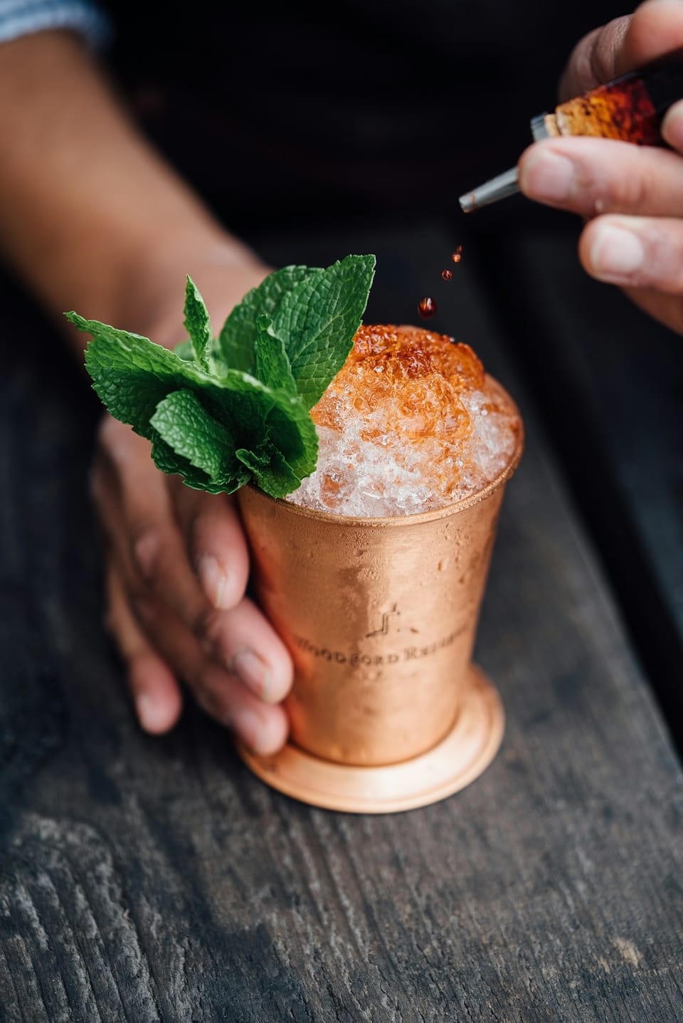 A cocktail with crushed ice and mint in a copper cup