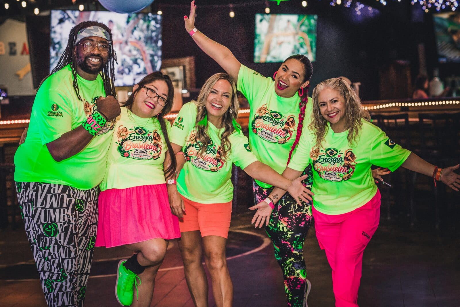 Instructors and guests posing mid-dance in neon outfits